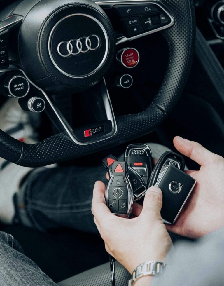 Detailed view of Audi car interior showcasing steering wheel and key fobs in hand for luxury vehicle lifestyle.